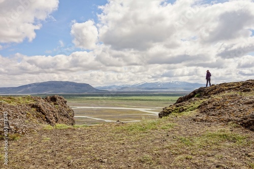 A brave unrecognizable woman facing her fear at Gaukshofdi Panoramic Lookout in Iceland photo