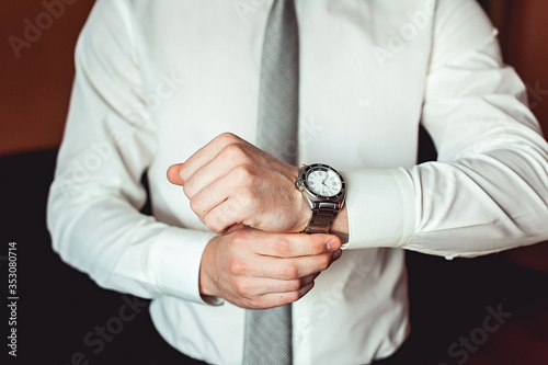 businessman checking time on his wrist watch, man putting clock on hand, groom getting ready in the morning