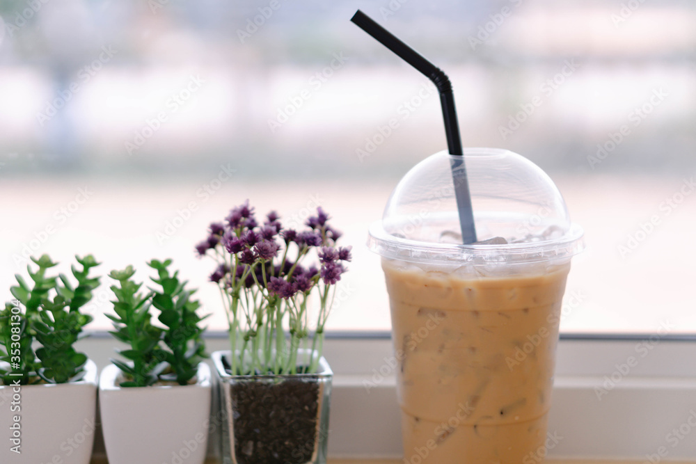 Closeup glass of ice coffee with flower pot in the coffee shop Closeup glass of ice coffee with flower pot in the coffee shop