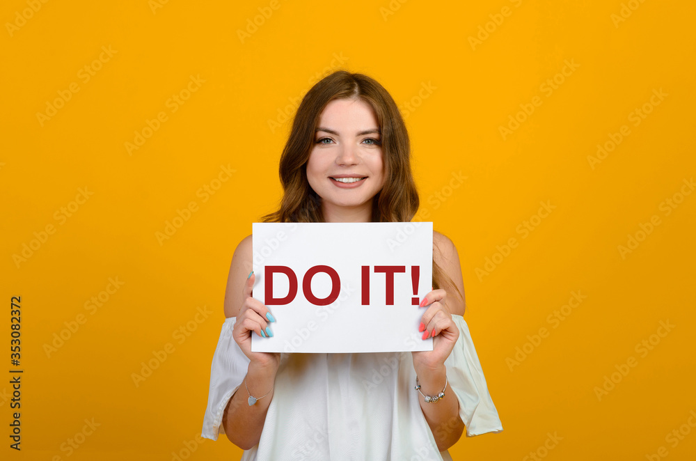 Dark-haired young woman with a smile and big suprised eyes posing on yellow background. Dark-haired young woman with a smile and big suprised eyes posing on yellow background.
