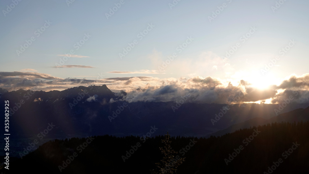 beautiful morning on the mountains with sunbeams and clouds and view to the alps