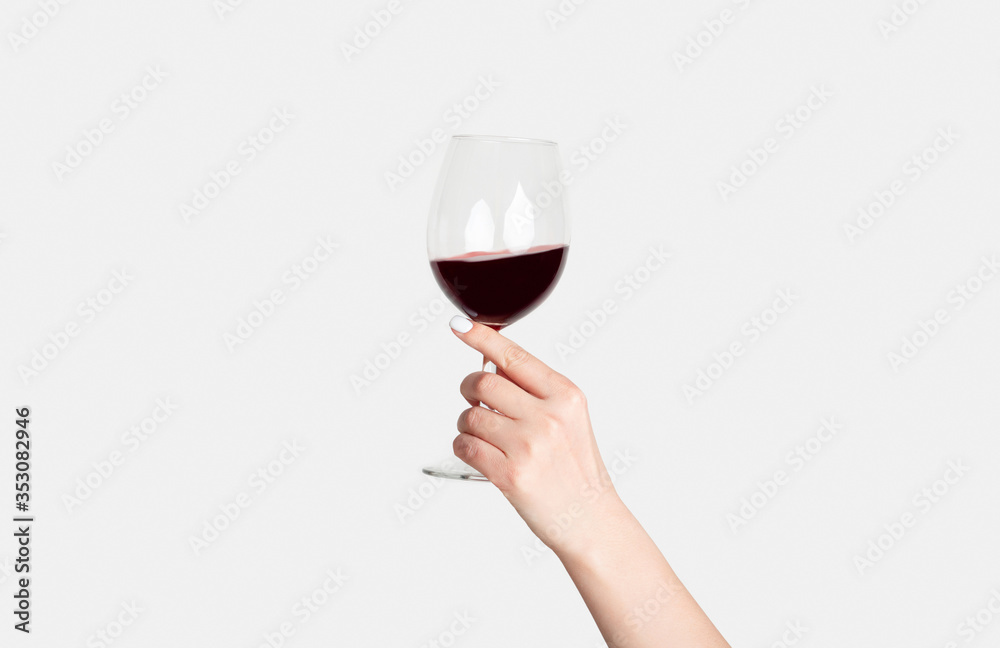 Young girl holding glass of tasty red wine on white background, closeup