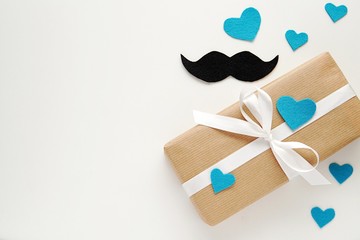 Happy fathers day, gift box with white ribbon, mustache and hearts made of felt fabric, copy space.