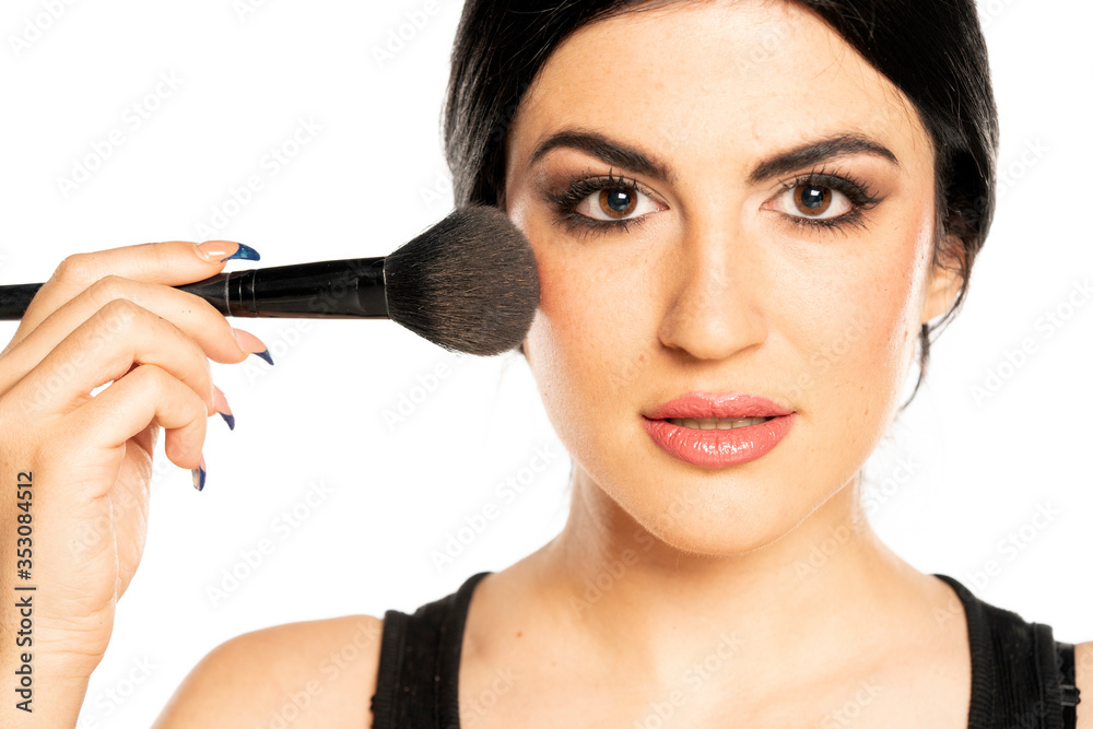 a young beautiful woman applying makeup with makeup brush a young beautiful woman applying makeup with makeup brush
