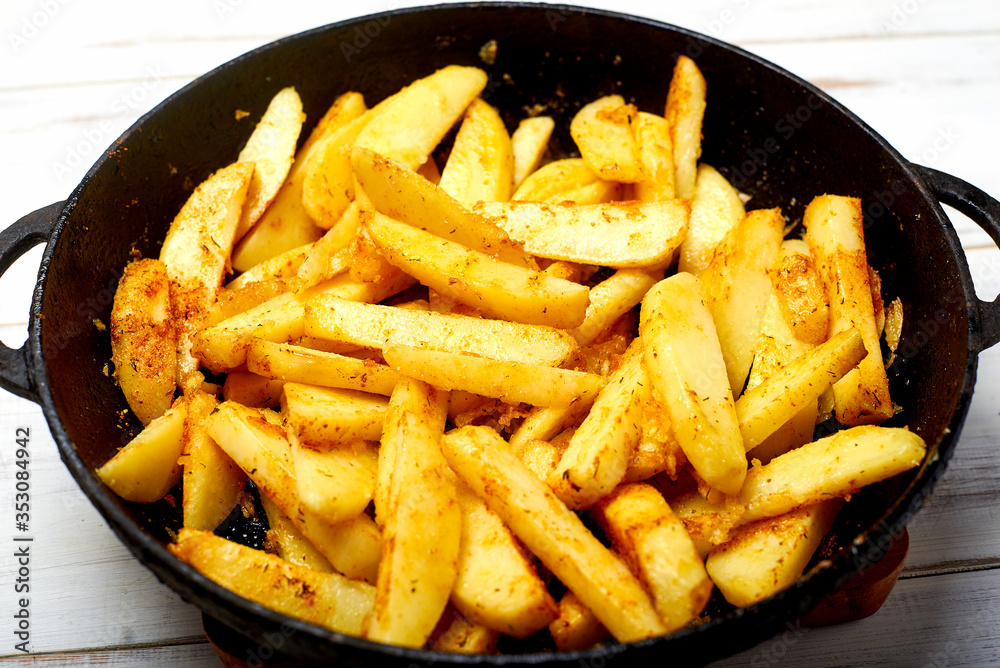 Cooking fried potatoes in a pan. Sliced potato with spices. Cooking fried potatoes in a pan. Sliced potato with spices.