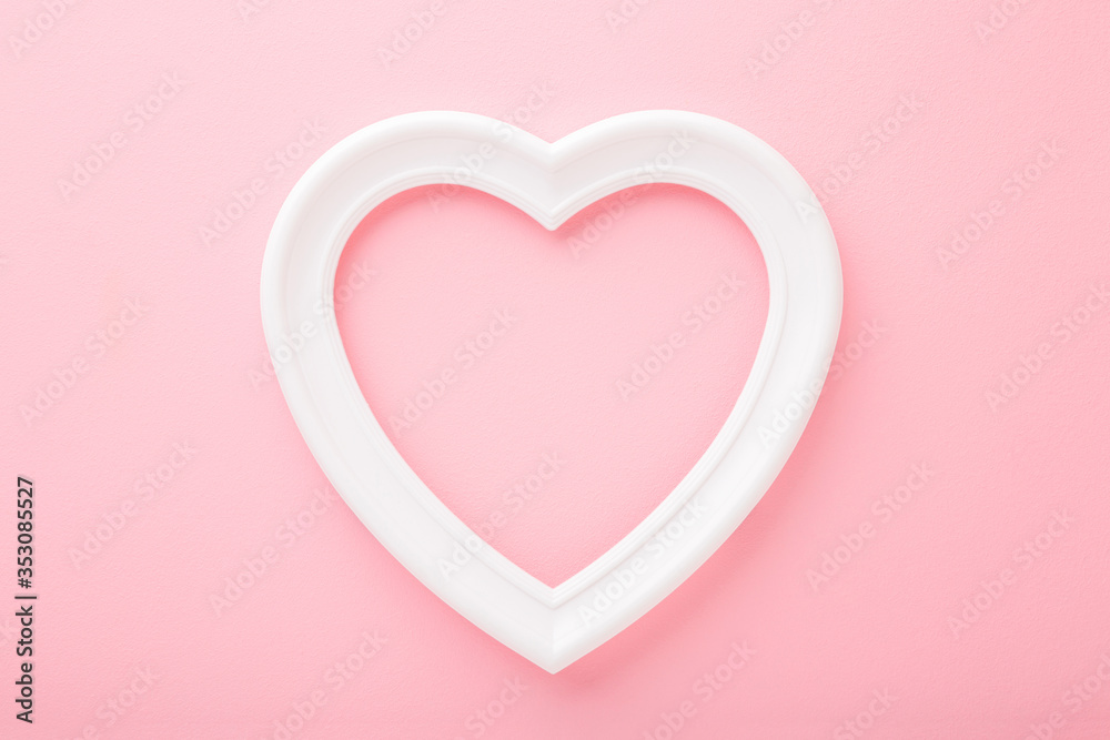 Frame of white heart shape on light pink table background. Pastel color. Love and happiness concept. Empty place for cute, emotional, sentimental text, quote or sayings. Closeup. Top down view.