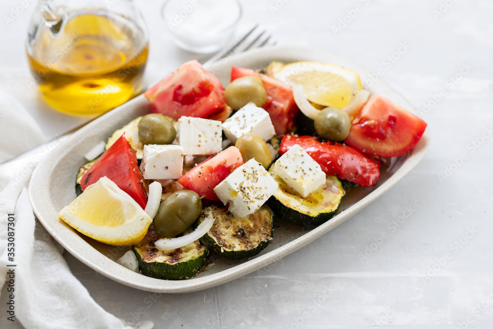 salad with fresh and grilled salad on white dish on gray ceramic background