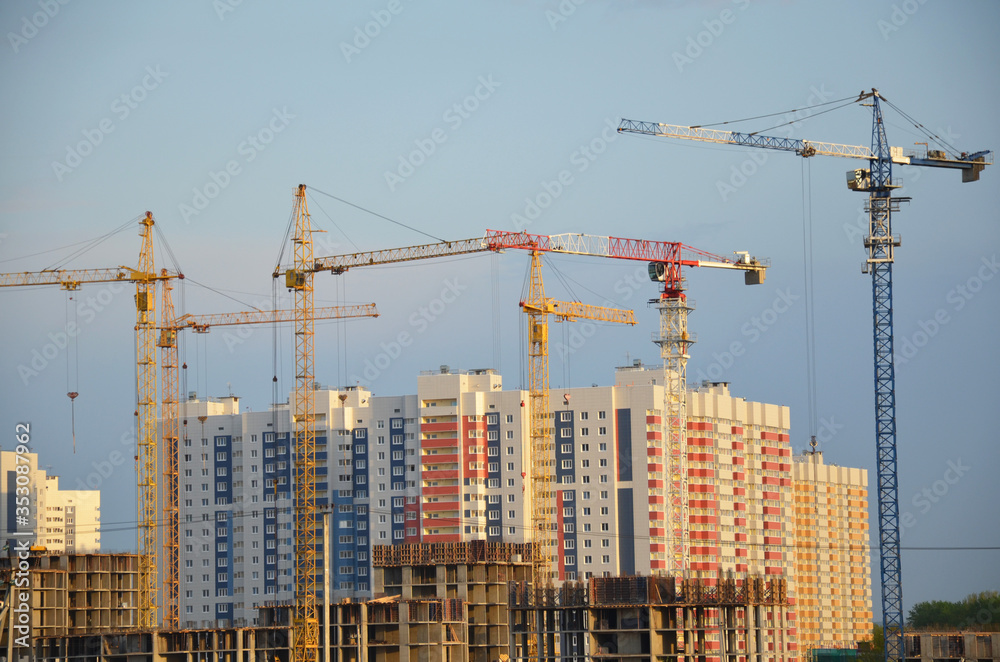Inside place for many tall buildings under construction and cranes under a blue sky working on place with tall homes Inside place for many tall buildings under construction and cranes under a blue sky working on place with tall homes