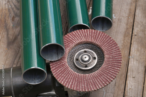 Steel pipes, angle grinder with mounted grit flap discs. Grinding.