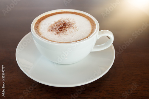 Coffee cup of cappuccino on wooden table in cafe