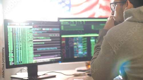 Programmer or hacker works at home in quarantine. Hacker code blinks of the monitor screen. Man writes code and programs. Internet online job. Self-isolation due to coronavirus