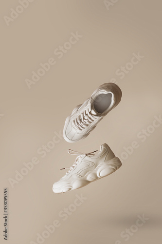Konstfotografi Modern women's sneakers of light color flying on a beige background
