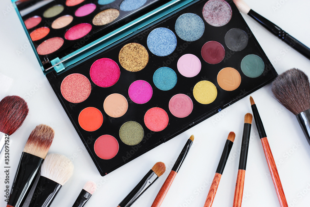 Top view of makeup shadows and brushes on a table. Top view of makeup shadows and brushes on a table.