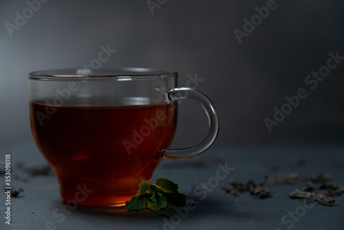 tea with mint and lemon on a dark background