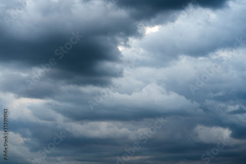 Bad weather with the sky completely covered by gray rain clouds placed in several layers  dark atmosphere with nimbus and cumulus clouds. Climate change causes extreme weather events.