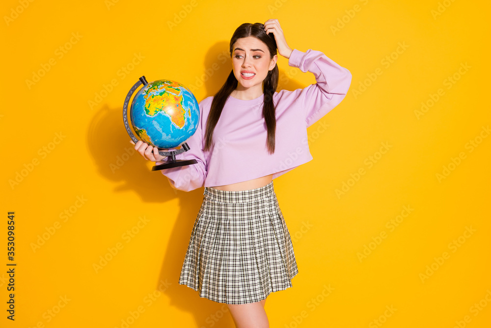 Fototapeta premium Portrait of frustrated school girl have geography lesson hold globe forget where europe located wear pullover style stylish trendy plaid clothes isolated over bright shine color background
