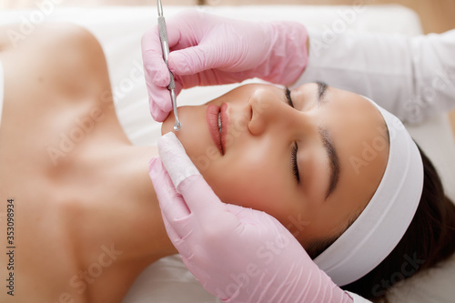 Young beautiful woman gets facial cleansing procedure in a beauty salon. Cosmetology.Cosmetic procedures for the face
