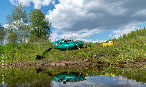 landscape with green rubber boat on the river shore  fisherman s equipment  Seda River  Latvia