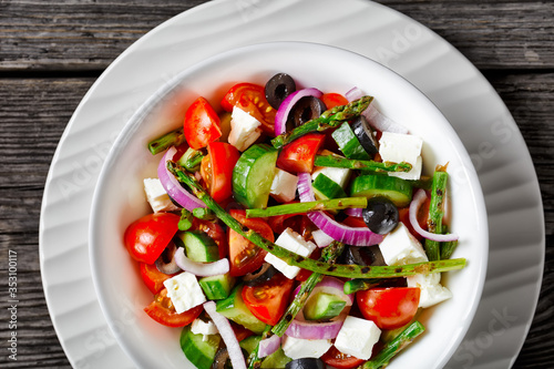 Fresh greek salad with grilled asparagus, close-up