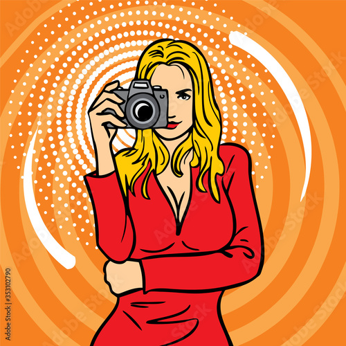 Expressive portrait of a beautiful young woman in a red dress on an orange background with a camera in her hands.