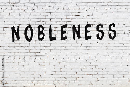 White wall with black paint inscription nobleness on it