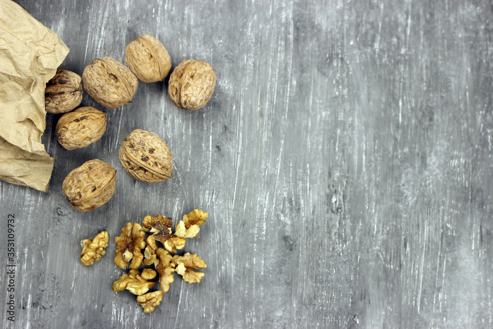 Walnut kernels and whole nuts on an old gray table. Seletive focus, copy space Walnut kernels and whole nuts on an old gray table. Seletive focus, copy space