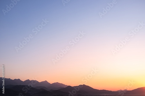 Dramatic sunset and sunrise over mountain morning twilight over evening sky horizon.