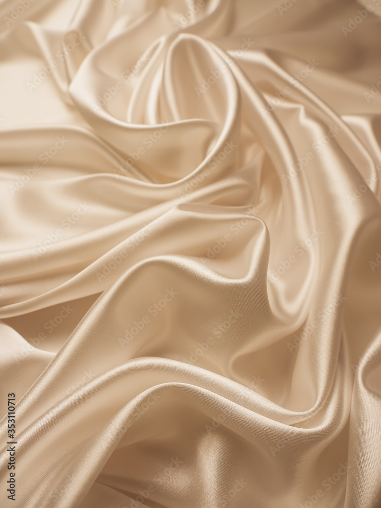 Beautiful smooth elegant wavy beige / light brown satin silk luxury cloth fabric texture, abstract background design. Copy space.
