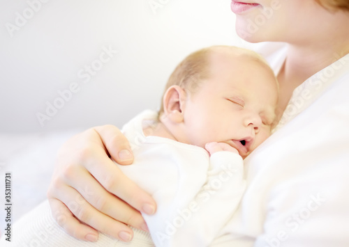 Mother holding her tiny newborn baby. Woman enjoy her first day's as a young mom with cute infant child. Mother day.