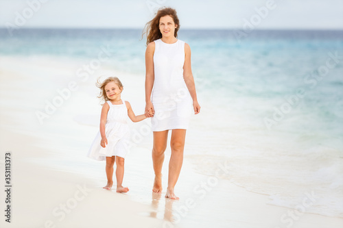 Mother and little daughter walking on beach on Maldives at summer vacation © sborisov