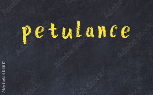 College chalk desk with the word petulance written on in photo