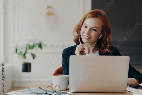 University student studies online from home, discusses project work with professor, poses in coworking space and drinks aromatic coffee. Video conference, vitrual event, online education concept photo