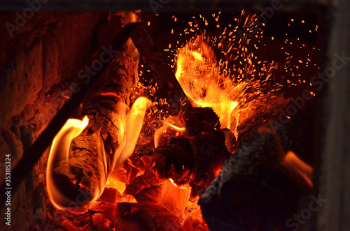 Sparks from fire in fireplace with bokeh balls.