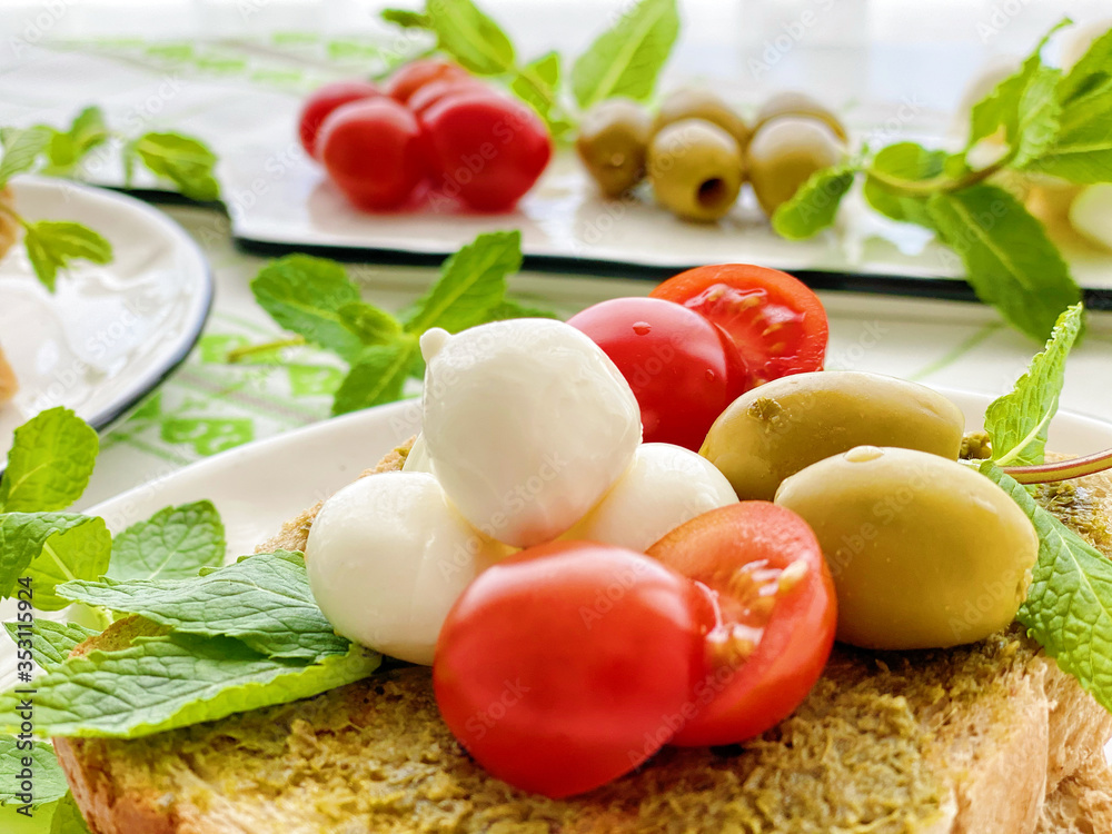 Baby mozzarella with cherry tomatoes on sliced bred.