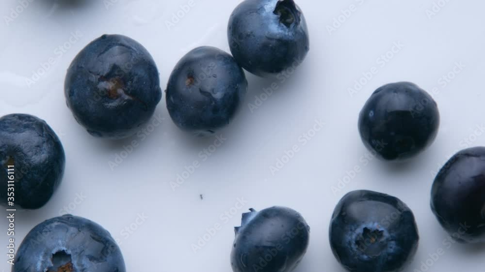 blueberries falling in super slow motion to the white table top view from above in slow motion from 120 fp blueberries falling in super slow motion to the white table top view from above in slow motion from 120 fp