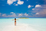 Young woman in bikini enjoing the beautiful ocean beach on Maldives