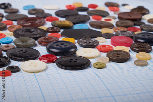 Colorful mixed sewing buttons on black background, flat lay. Top view.