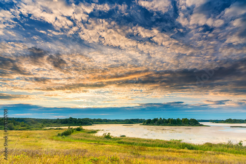 Clouds above the lake in a countryside at summer evening