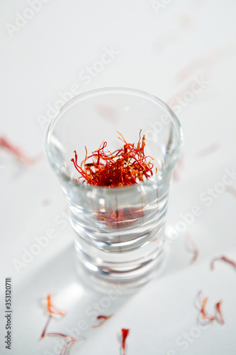 Saffron strand into the crystal glass on the white background