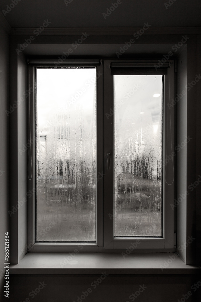 Fototapeta premium A window with fogged windows in the room.