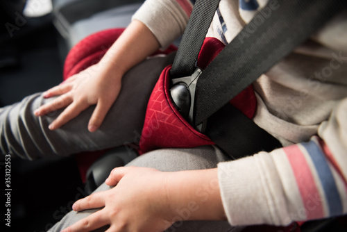 A close up of a child infants seat belt tightly fixed in place, for security and protection of toddlers travelling in a car. Child protection in automobiles and baby booster seats.