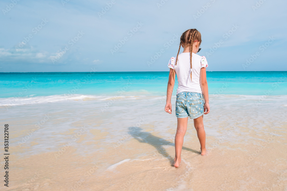 Adorable little girl have fun at tropical beach during vacation Adorable little girl have fun at tropical beach during vacation