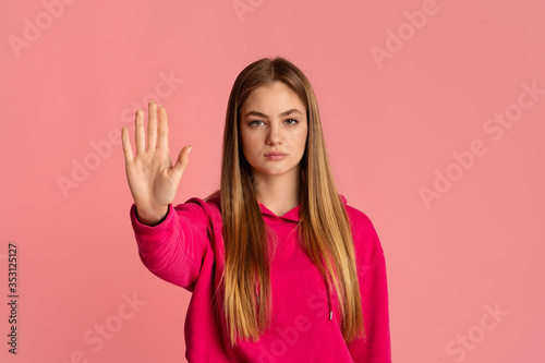 Wallpaper Mural Stop gesture. Strict teenage girl in pink hoodie raises hand Torontodigital.ca