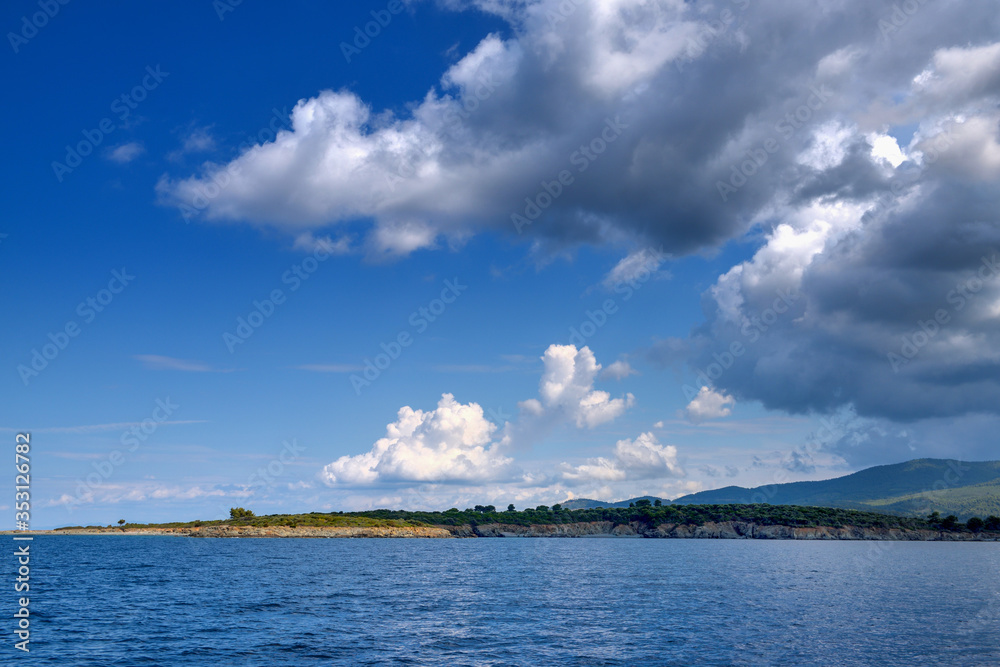 View of the shore from the sea. Panorama with the sea and stormy clouds in the sky
