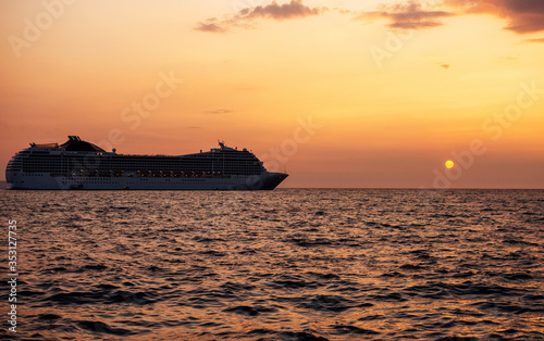 Cruise liner in open sea. Passenger ferry sailing at hot sunset