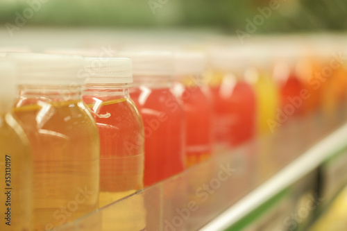 Banner of number colorful drinks in plastic bottles on the shelves of supermarket. Selective Focus.