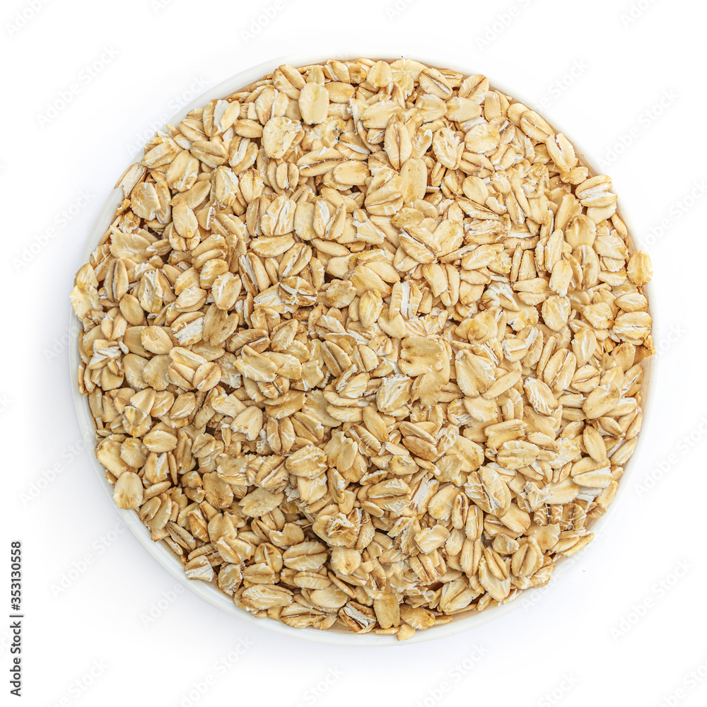 Oat flakes in a bowl isolated on white background. Pile of oatmeal top view Oat flakes in a bowl isolated on white background. Pile of oatmeal top view