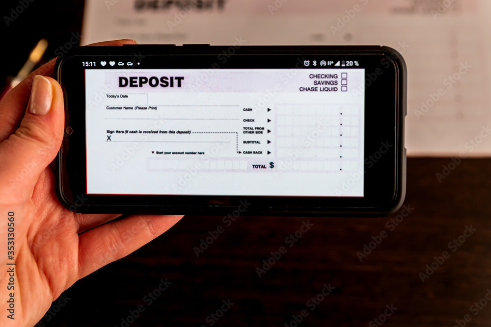 Man Taking Photo Of Cheque To Make Remote Deposit In bank Man Taking Photo Of Cheque To Make Remote Deposit In bank