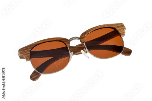 Glasses with wood-metal rim and brown-orange glasses folded on white background