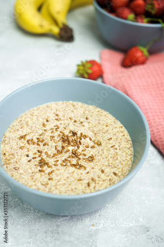 Flax porridge with banana and strawberries on a light background. Healthy breakfast
